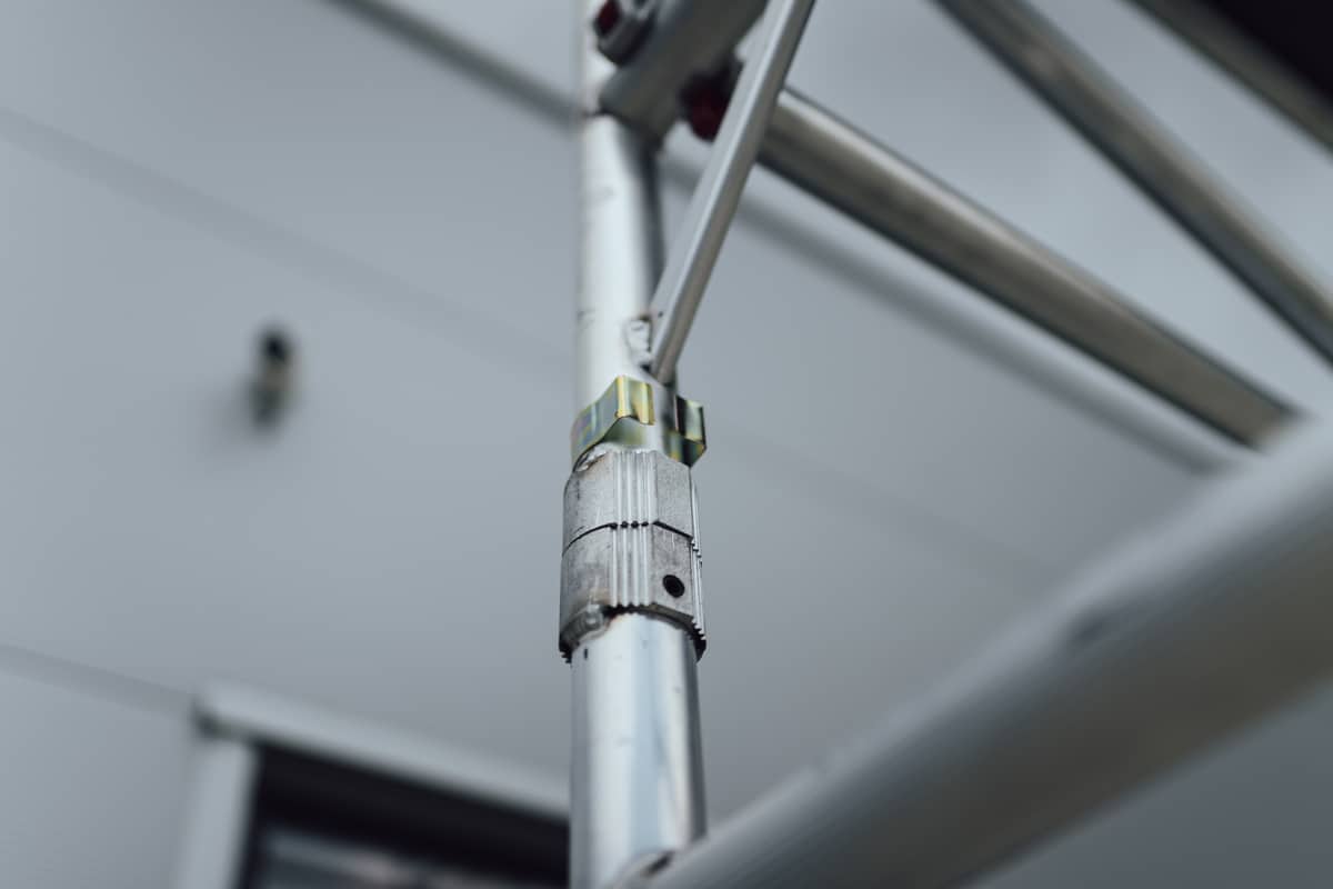 Detail spojky a poistného mechanizmu na hliníkovej rúrke lešenia